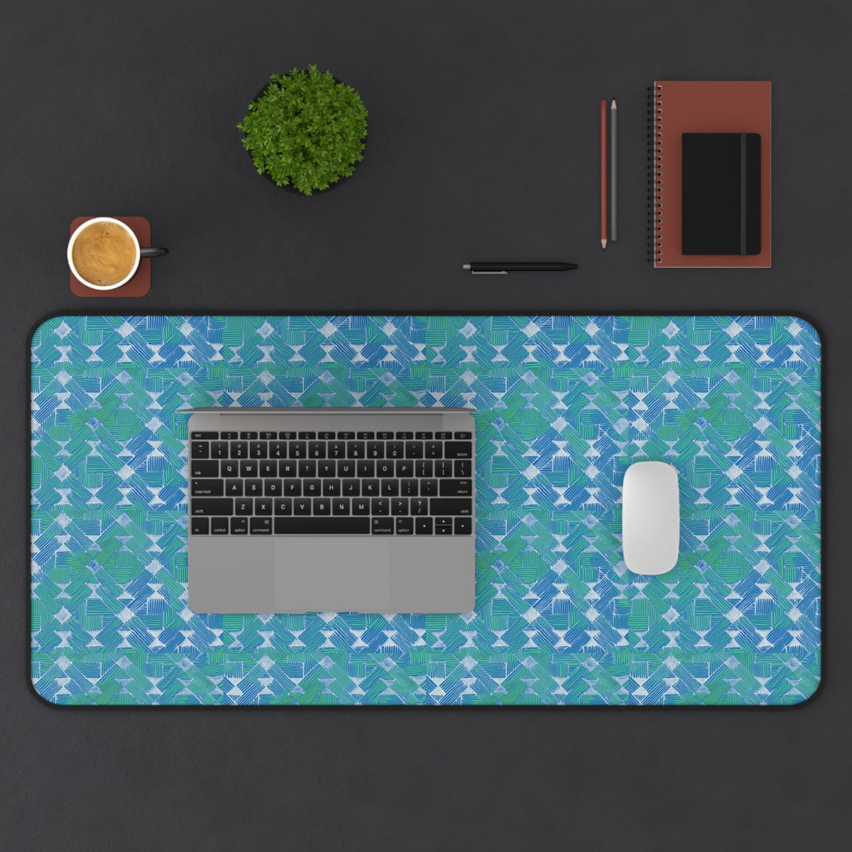Blue Green Abstract Waves Desk Mat — Patterned Office Mousepad, extra-wide large desk mat arranged with a laptop, mouse, coffee, and stationery