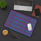 Geometric Neon Wave Desk Mat — Retro Purple & Teal Gamer Desk Pad, angled gaming desk mat lifestyle view with laptop, mouse, notebooks, and coffee.