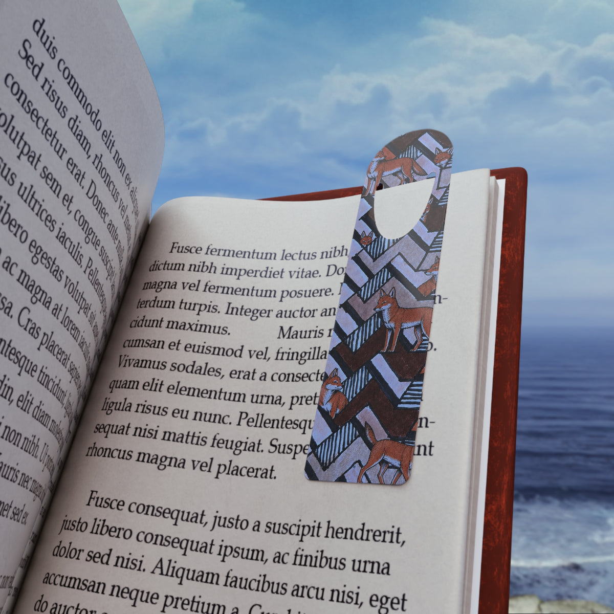 Horse Pattern Metal Bookmark – Geometric Fox & Pony Design, colorful foxy page marker holding a place in an open book by the ocean