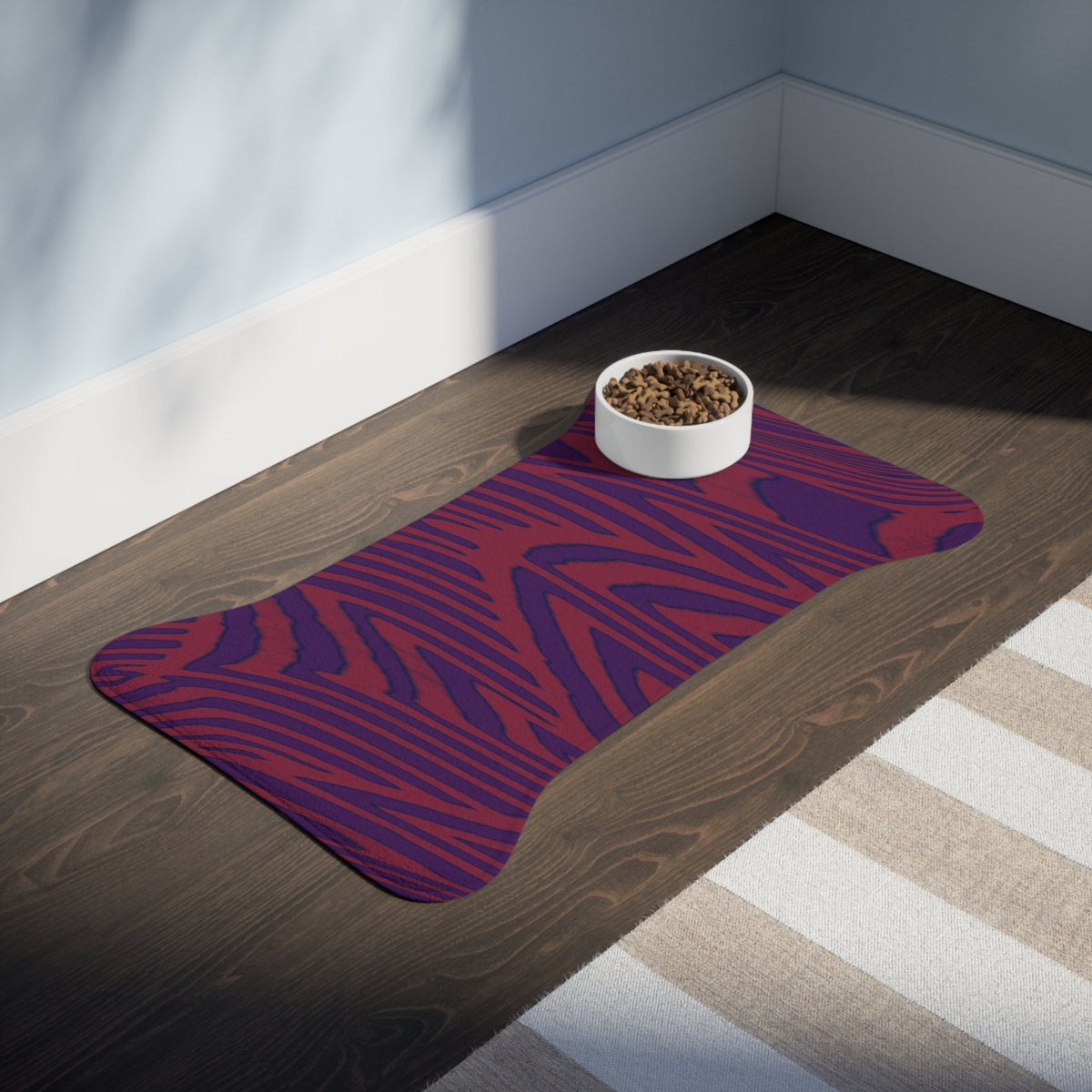 An elegant Pet Feeding Mat in a wood grain print on a wooden floor, promoting a chic feeding space for pets. This memory foam dog mat not only serves as a stylish dog placemat but also as a versatile cat placemat. This non-slip mat ensures stability while looking great in any home decor.
