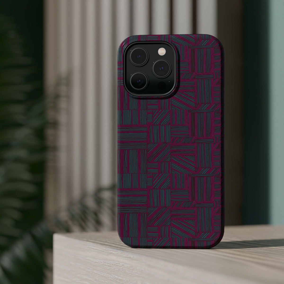 Slim Protective Phone Case With MagSafe, Dual-Layer Impact Protection, Plum Geometric Design, artistic lifestyle render of a protected phone against a dark teal background; slim protective iphone 16 promax  case.