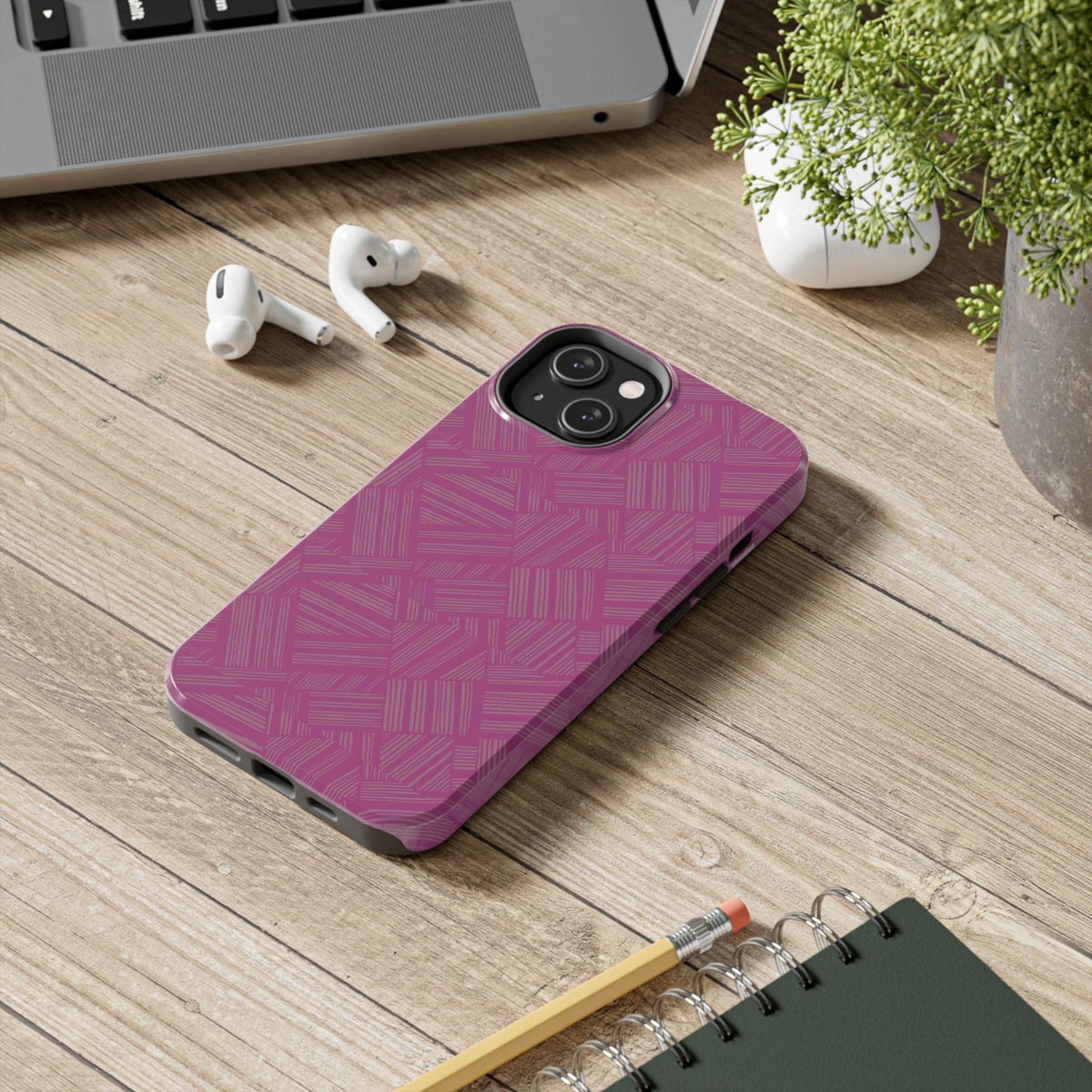 Magenta Geo Pattern Tough Phone Case — Protective Floral-Style Abstract Design, wireless charging iphone 18 pro case photographed beside a laptop and earbuds.