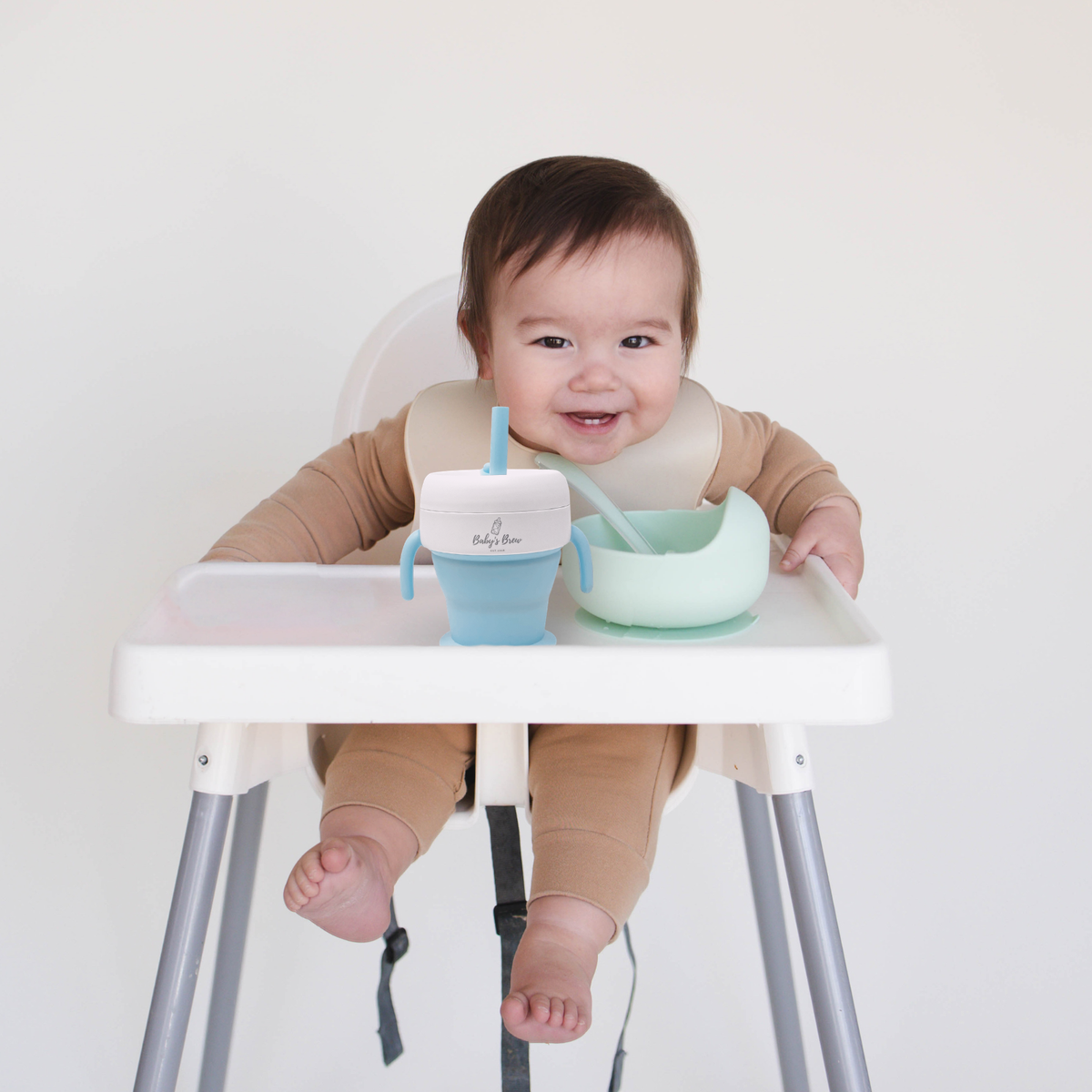 Bite Size Bundle featuring Baby's Brew toddler feeding set with snack cup, suction bowl, and spoons on a high chair tray