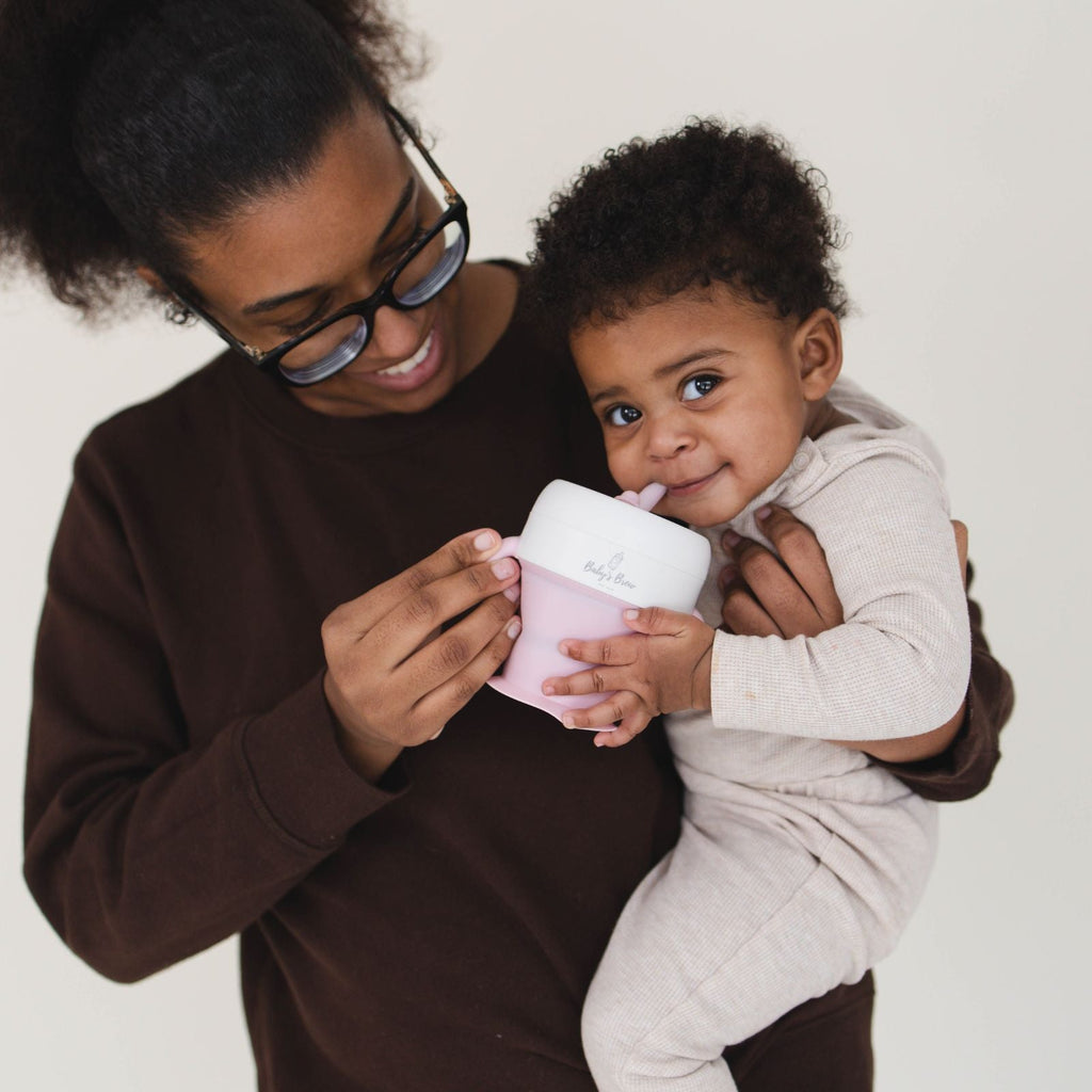Parent feeding a baby with the Bite Size Bundle Baby's Brew toddler feeding set snack cup
