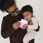 Parent feeding a baby with the Bite Size Bundle Baby's Brew toddler feeding set snack cup