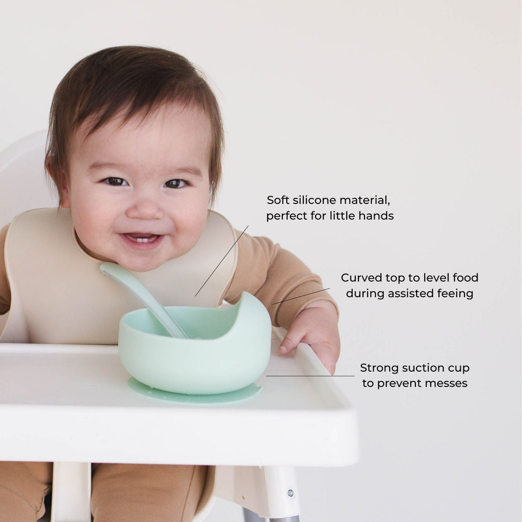 Baby using the suction bowl from the Bite Size Bundle Baby's Brew toddler feeding set during mealtime