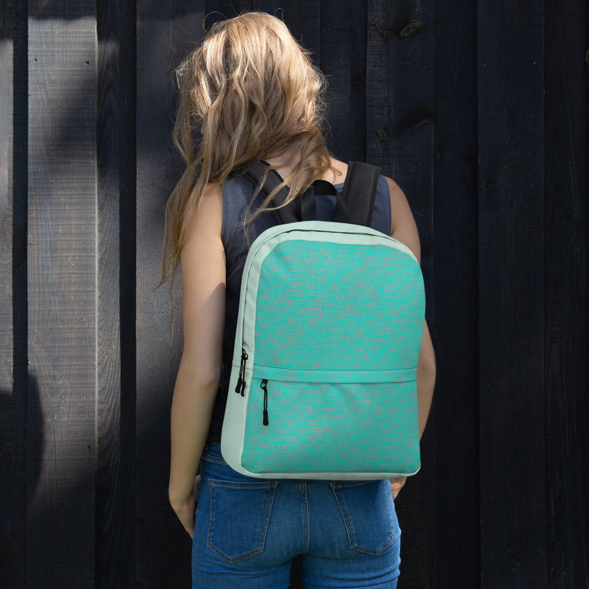 Back of a medium size backpack shown on a young woman, ideal for back to school. The backpack combines functionality and style, featuring a sleek design against a wooden backdrop.