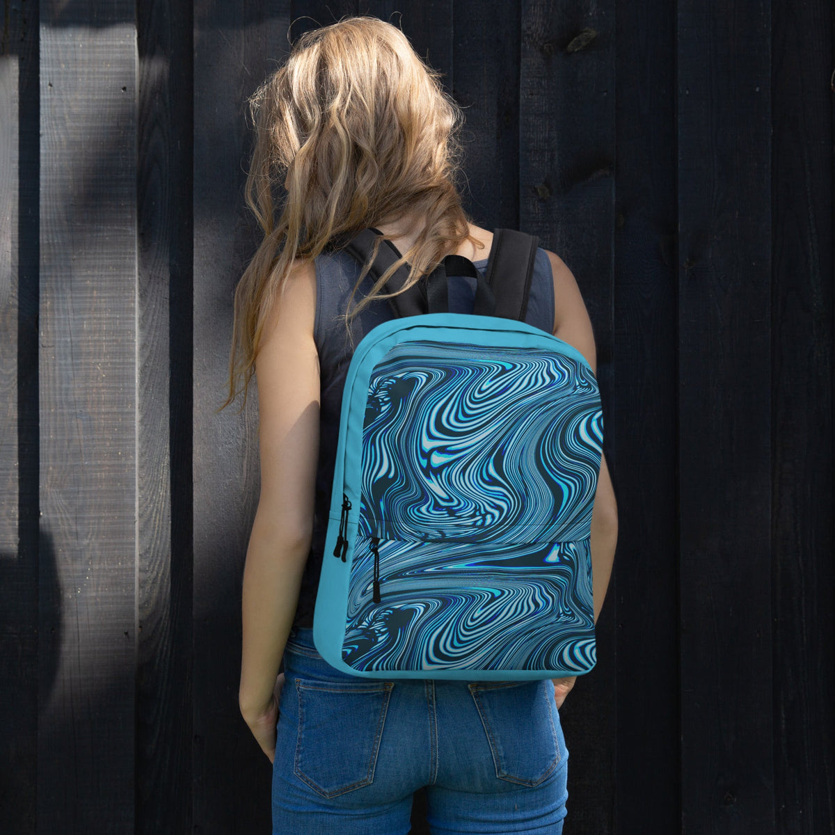 Back view of a medium size backpack designed for back to school 2026, showcasing its eye-catching blue and black swirl pattern, worn by a woman.