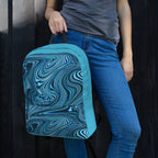 Close-up of a colorful medium size backpack ideal for back to school 2026, held by a woman, highlighting its unique blue and black swirl design.