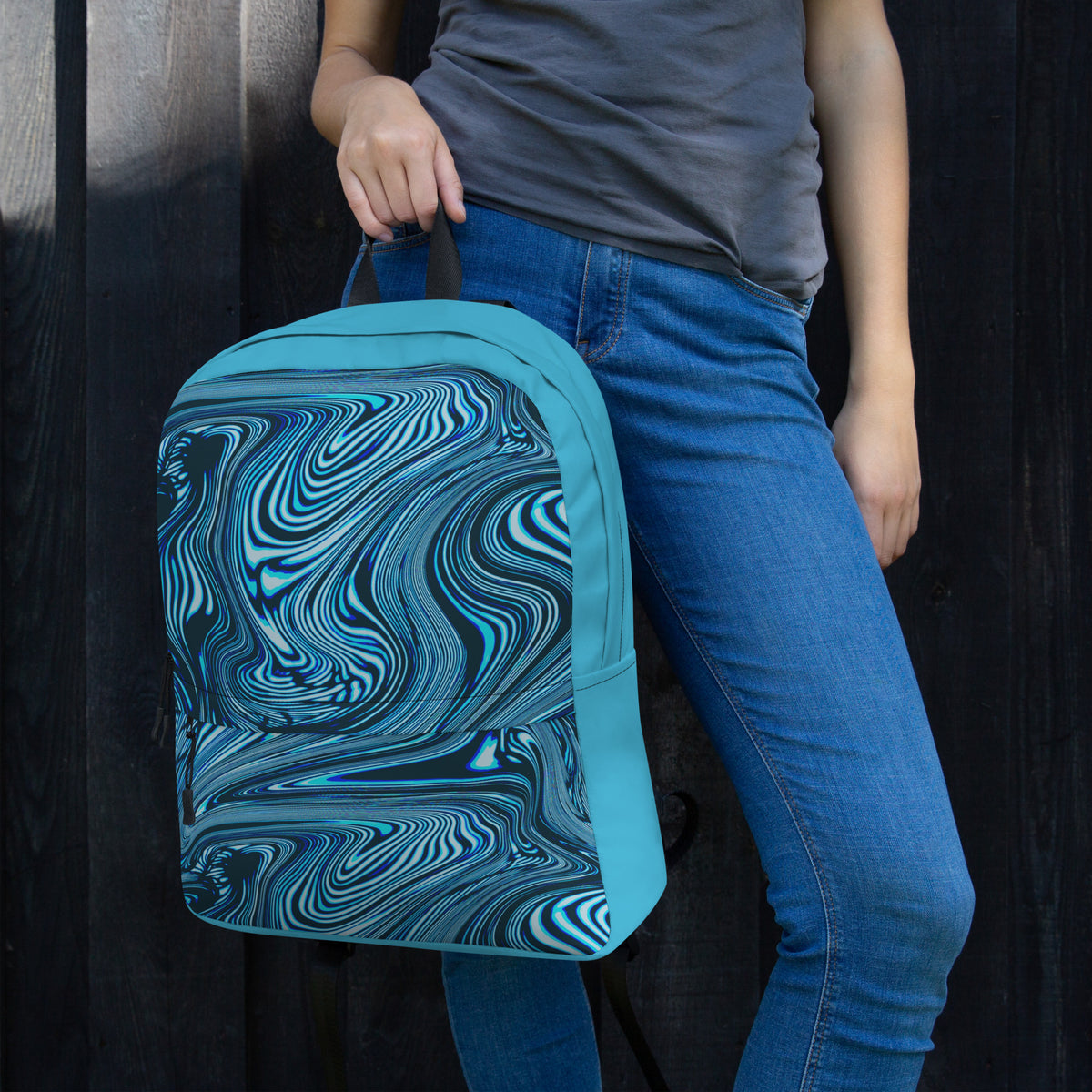 Close-up of a colorful medium size backpack ideal for back to school 2026, held by a woman, highlighting its unique blue and black swirl design.