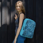 Stylish medium size backpack perfect for back to school 2026, featuring a vibrant blue and black swirl design, carried by a woman on her shoulder.
