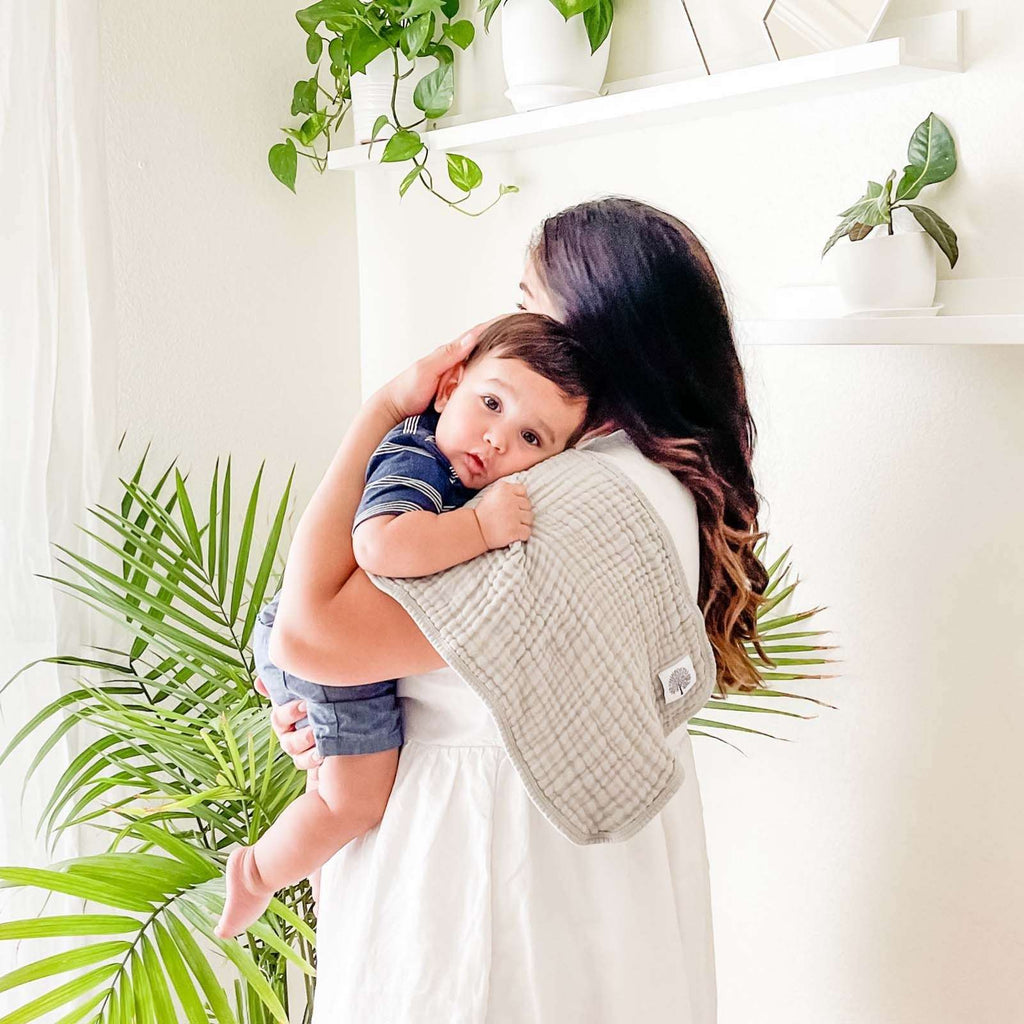 Butterfly Set - Muslin Burp Cloths (4 Pack) absorbent burp cloths for under 2, shown over a mother's shoulder while she carries her child.