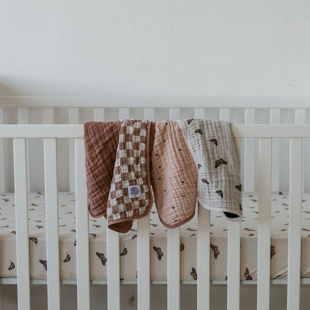 Butterfly Set - Muslin Burp Cloths (4 Pack) absorbent burp cloths for under 2, draped over a white crib rail.